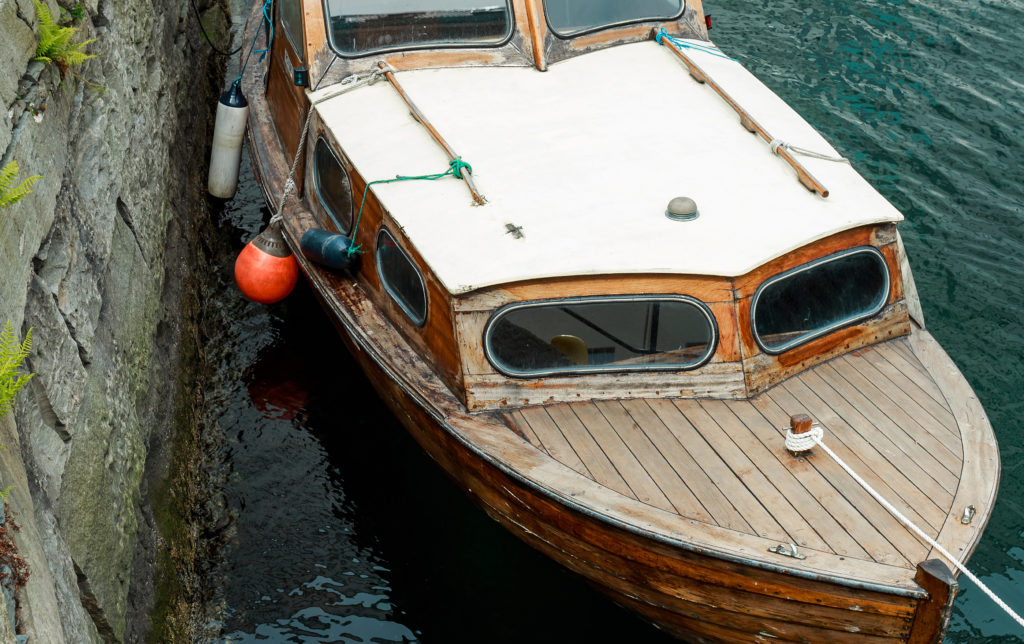 Old wooden row boat on water in Norway - Til-vanns.no
